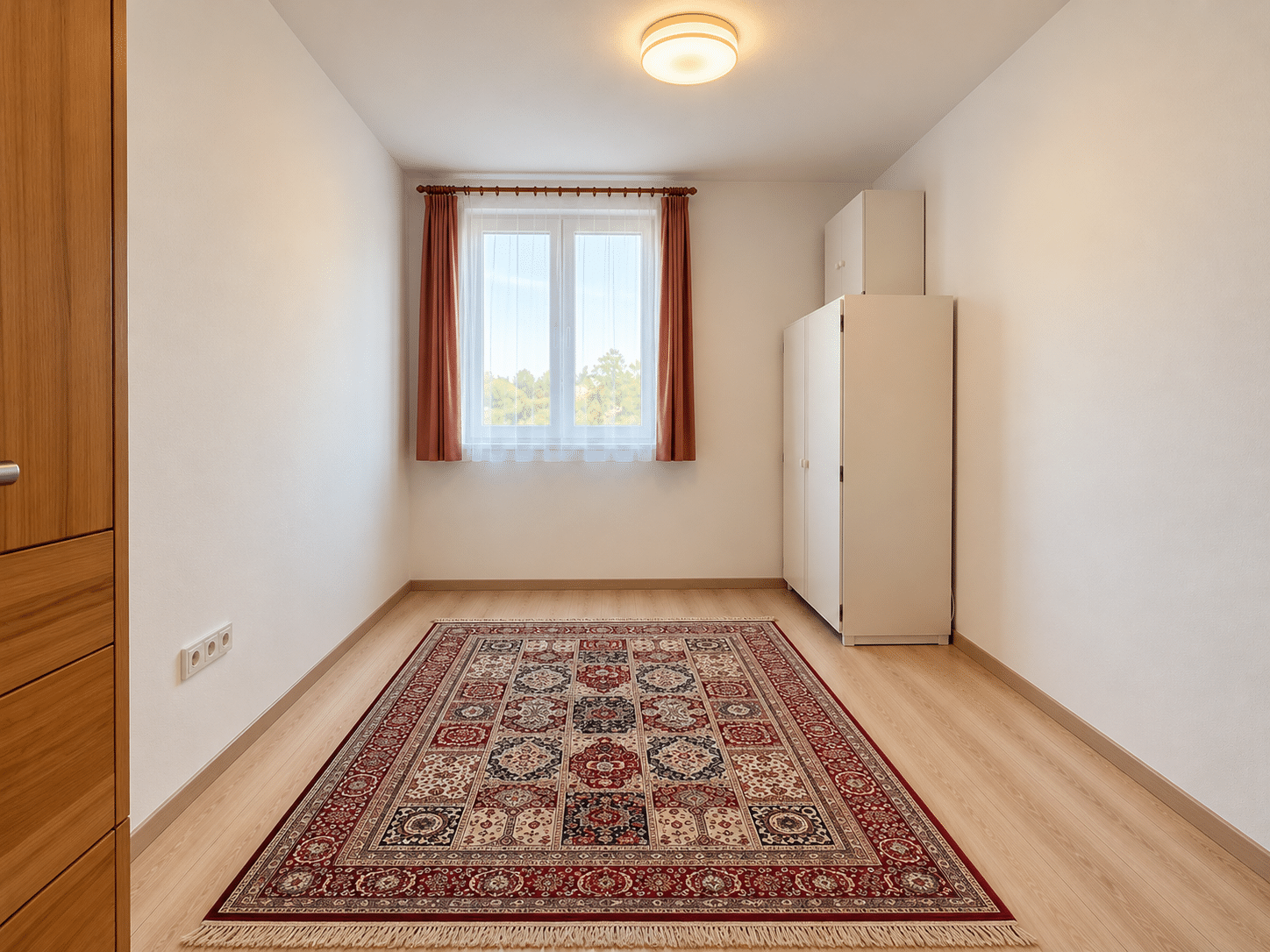 Minimalista szoba perzsaszőnyeggel és ablakkal